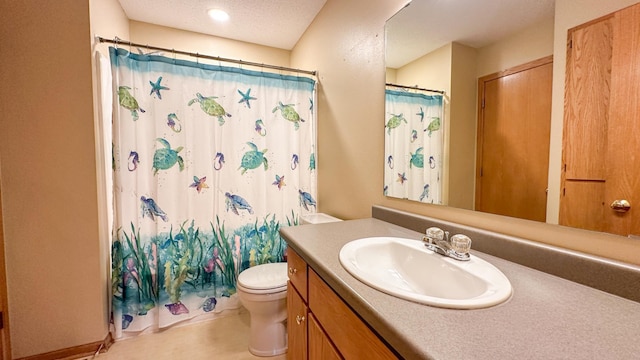 bathroom with vanity, toilet, walk in shower, and a textured ceiling