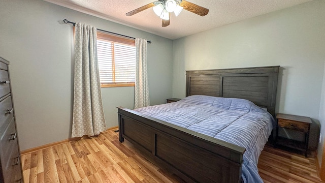 bedroom featuring light hardwood / wood-style flooring, a textured ceiling, and ceiling fan