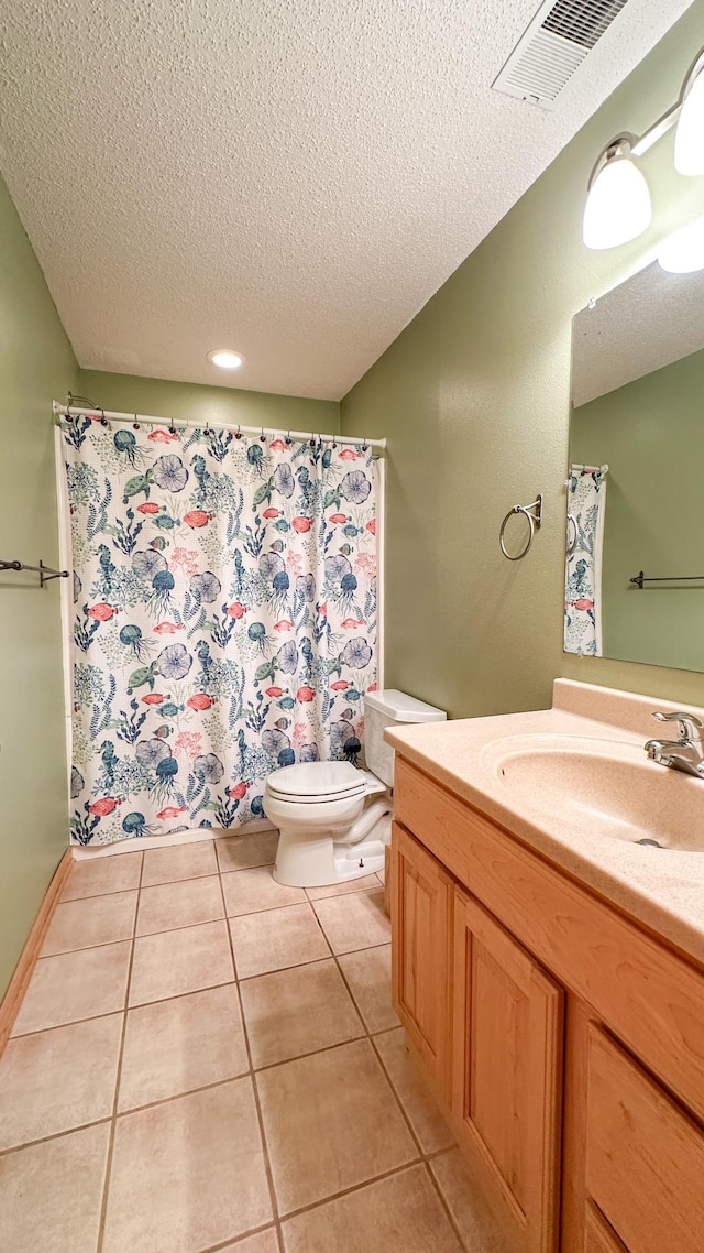 bathroom featuring toilet, a textured ceiling, vanity, and tile patterned flooring