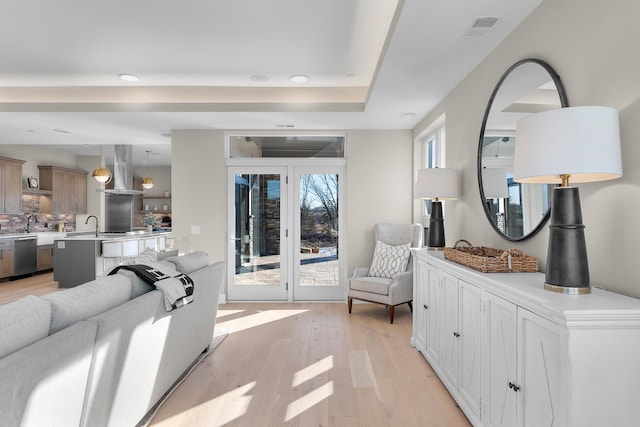 living room featuring sink and light hardwood / wood-style flooring