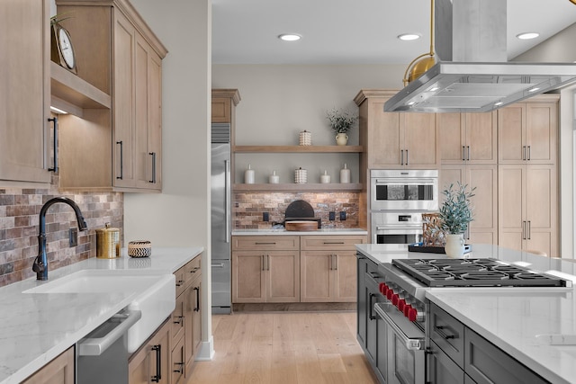 kitchen featuring sink, light hardwood / wood-style flooring, stainless steel appliances, light stone counters, and island exhaust hood