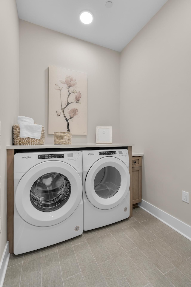 laundry area featuring washer and clothes dryer and cabinets