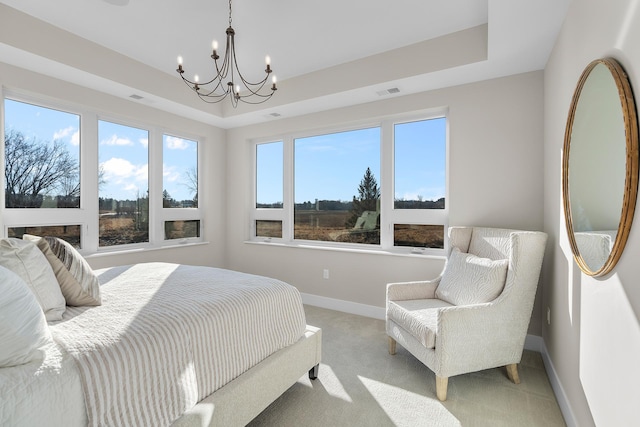 bedroom with light carpet, a raised ceiling, and an inviting chandelier