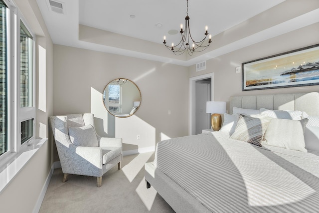 bedroom with a raised ceiling, light carpet, and an inviting chandelier