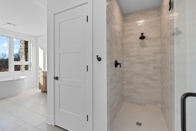 bathroom with vanity, tile patterned flooring, and plus walk in shower