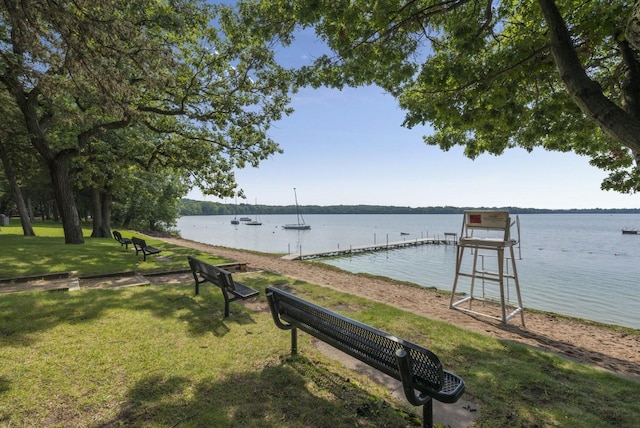 dock area featuring a lawn and a water view