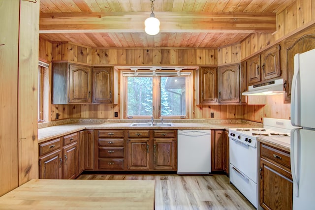 kitchen with under cabinet range hood, white appliances, brown cabinets, and a sink