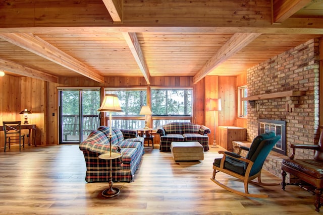 living area featuring wooden walls, beamed ceiling, a wealth of natural light, and wood finished floors
