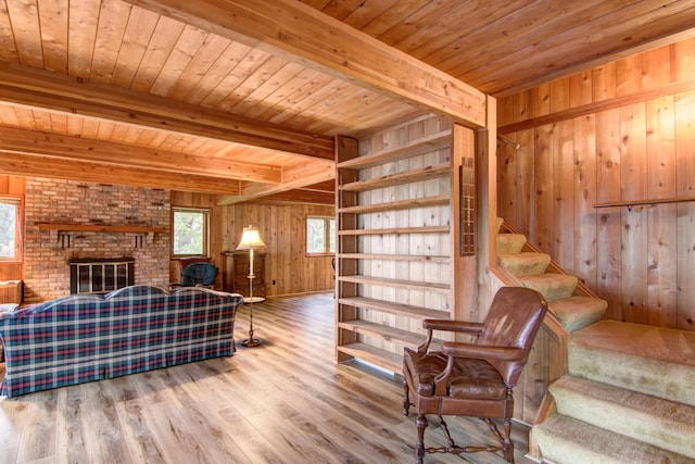 living room featuring wood ceiling, wooden walls, beam ceiling, wood finished floors, and stairs