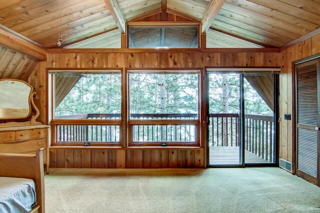 unfurnished bedroom with access to outside, wooden walls, lofted ceiling, and carpet floors