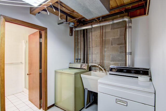laundry area featuring separate washer and dryer, laundry area, a sink, and concrete block wall