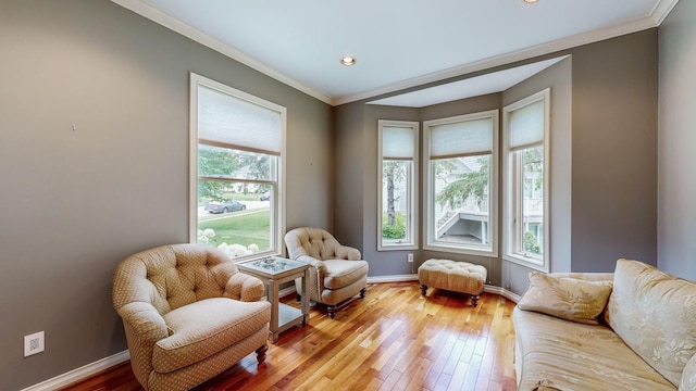 sitting room with hardwood / wood-style flooring and crown molding