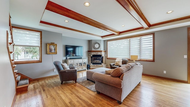 living room with a fireplace, light hardwood / wood-style floors, and beam ceiling