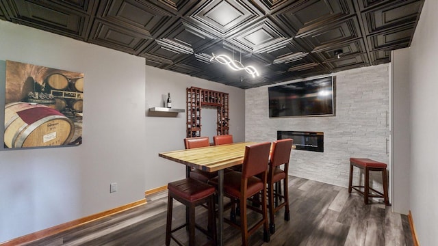 dining area featuring a large fireplace and dark hardwood / wood-style floors