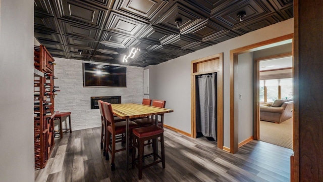 dining space featuring a fireplace and dark hardwood / wood-style flooring