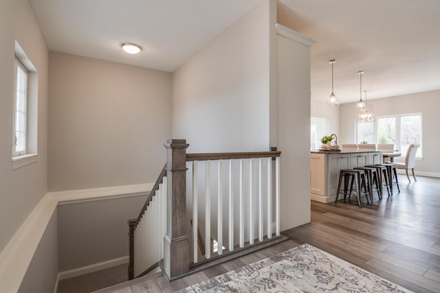 stairway with an inviting chandelier and hardwood / wood-style floors