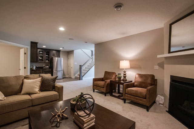 carpeted living room with a tile fireplace