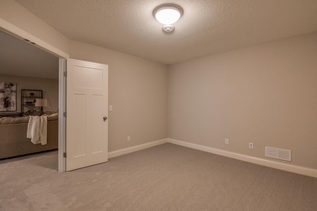 carpeted spare room with a textured ceiling