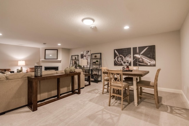 carpeted dining area featuring a textured ceiling