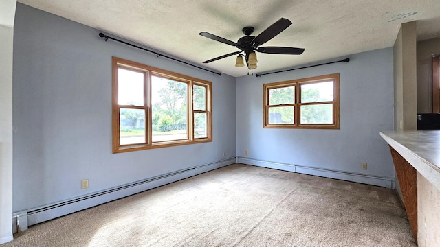 unfurnished dining area featuring baseboard heating, ceiling fan, light carpet, and a textured ceiling