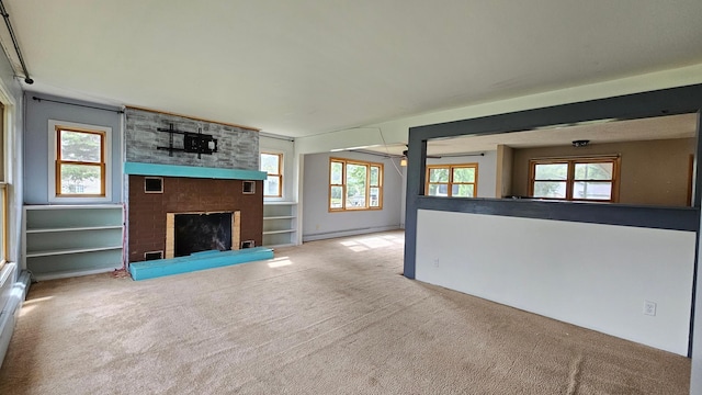 unfurnished living room featuring a fireplace, baseboard heating, and carpet