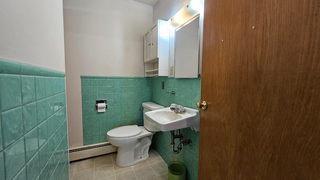 bathroom with tile patterned flooring, toilet, sink, tile walls, and a baseboard radiator