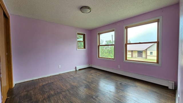 empty room with dark wood-type flooring, a textured ceiling, and baseboard heating