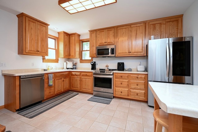 kitchen featuring light countertops, light tile patterned flooring, recessed lighting, and appliances with stainless steel finishes