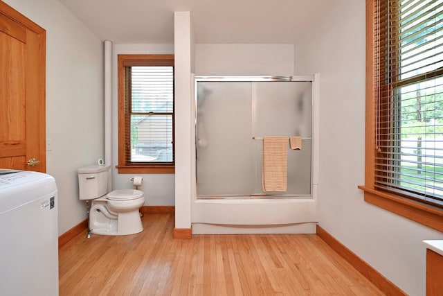 full bath with plenty of natural light, toilet, and wood finished floors