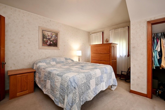 bedroom with wallpapered walls, baseboards, a closet, and light carpet