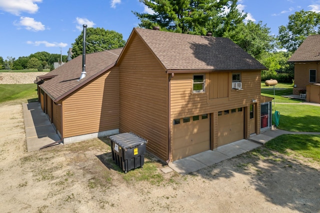 view of home's exterior with a lawn, dirt driveway, and a shingled roof