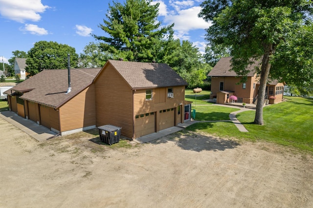 exterior space with dirt driveway, a yard, a garage, and roof with shingles