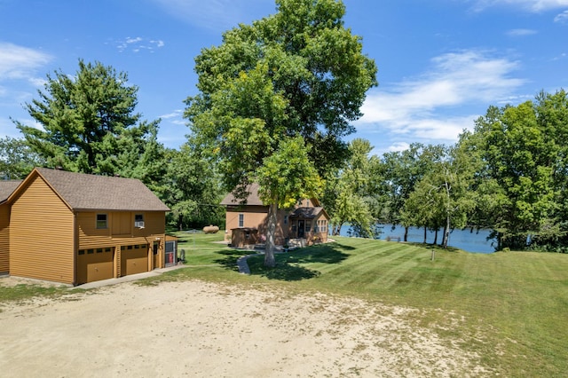 view of yard featuring a detached garage and a water view