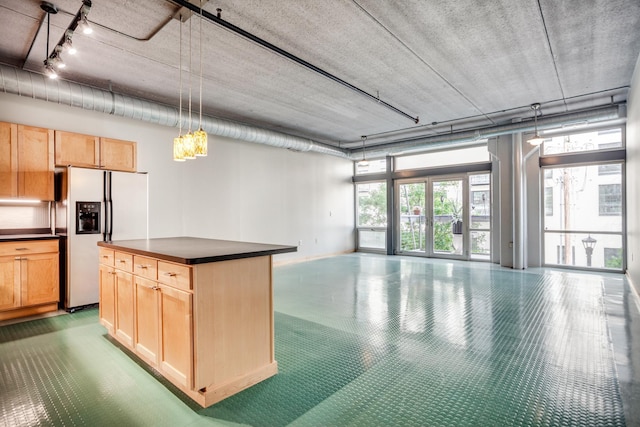 kitchen with fridge with ice dispenser, light brown cabinetry, and decorative light fixtures