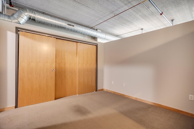 unfurnished bedroom featuring carpet flooring and a closet