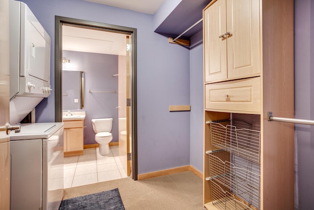 bathroom with tile patterned flooring, stacked washer / drying machine, toilet, and vanity