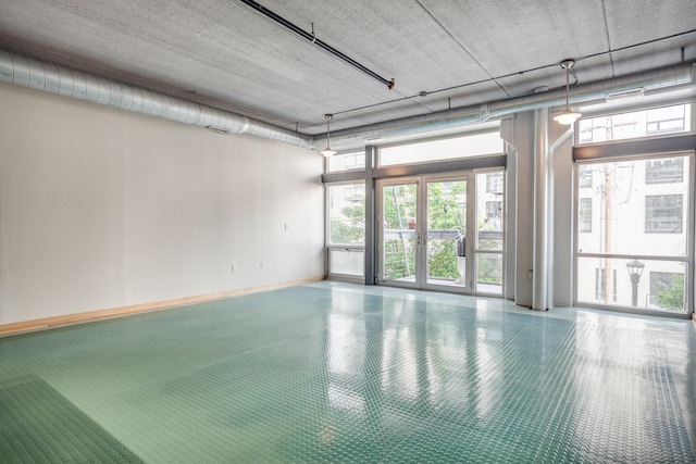 unfurnished room with baseboards and french doors