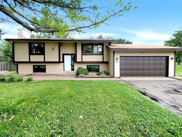 raised ranch with a garage and a front lawn