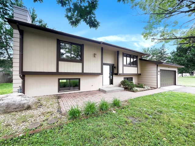 split foyer home featuring a garage and a front lawn