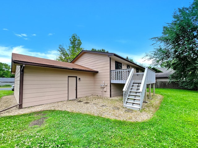 back of house featuring a wooden deck and a yard