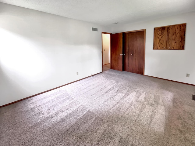 unfurnished bedroom featuring light carpet and a closet