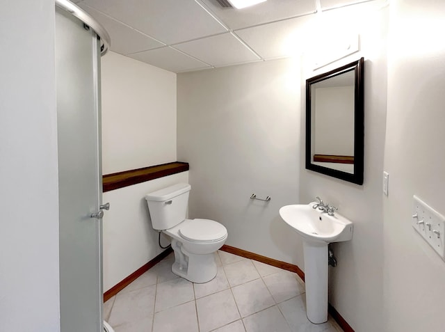 bathroom featuring a paneled ceiling, sink, tile patterned flooring, and toilet