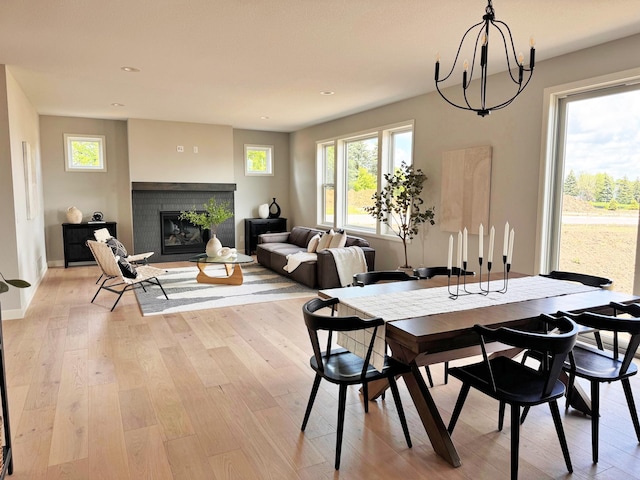 dining area featuring recessed lighting, a fireplace, light wood-style flooring, and a healthy amount of sunlight