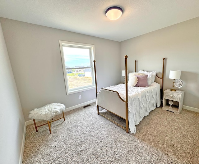 bedroom with visible vents, light carpet, baseboards, and a textured ceiling