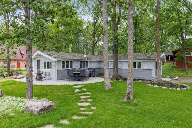 back of property with a patio area, an outdoor structure, and a yard