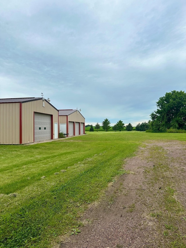 view of yard with a garage and an outbuilding