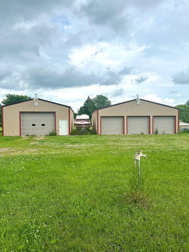 view of yard with a garage and an outbuilding