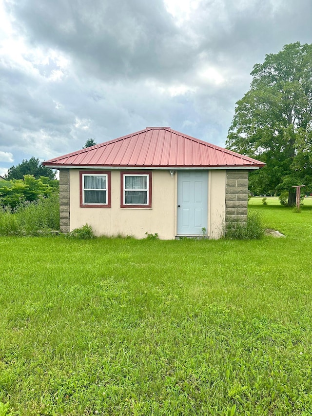 view of side of home with a yard and an outbuilding