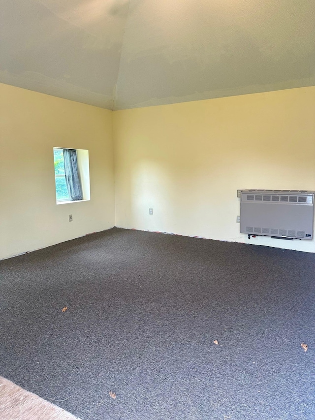 empty room featuring carpet and vaulted ceiling