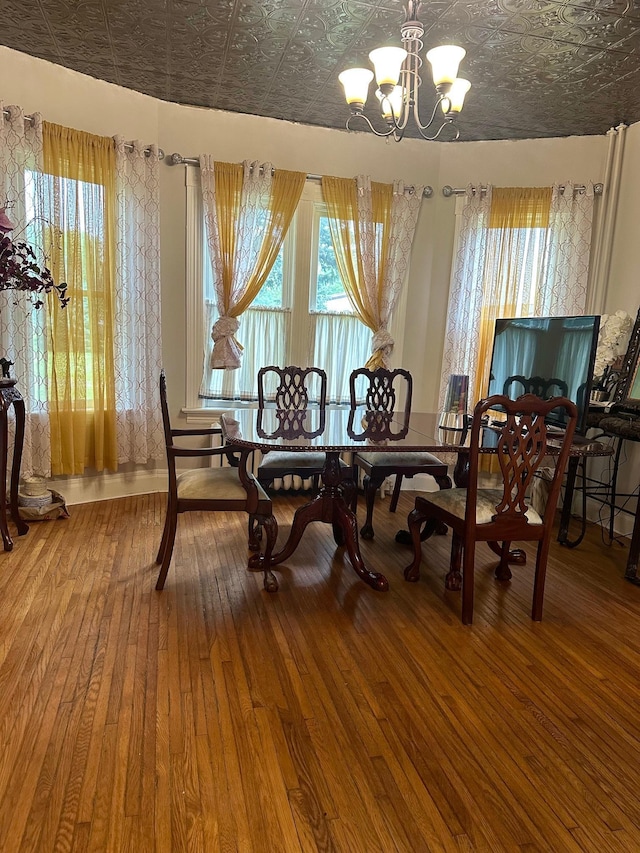 dining area with wood-type flooring and a notable chandelier